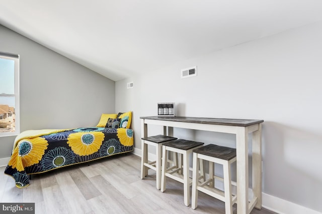 bedroom with light hardwood / wood-style floors and vaulted ceiling