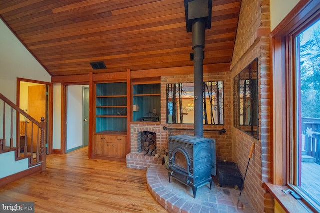 unfurnished living room featuring a wood stove, wood ceiling, lofted ceiling, and hardwood / wood-style flooring