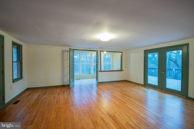 unfurnished room featuring french doors, a healthy amount of sunlight, and light wood-type flooring