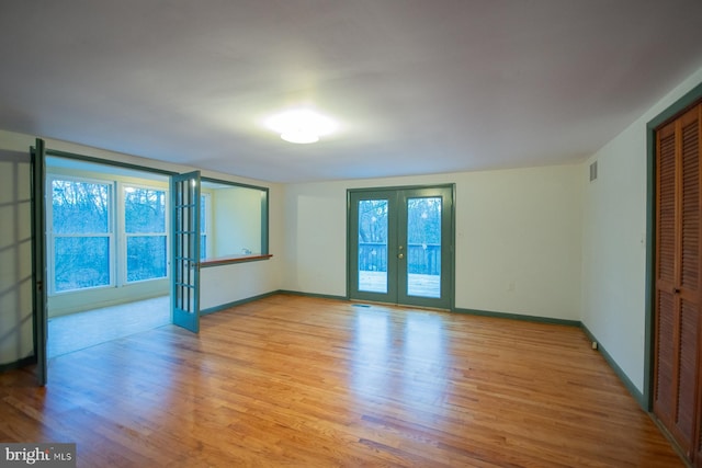 spare room featuring light hardwood / wood-style floors and french doors