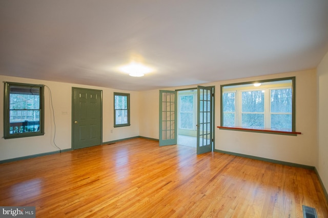 unfurnished room featuring light wood-type flooring and french doors