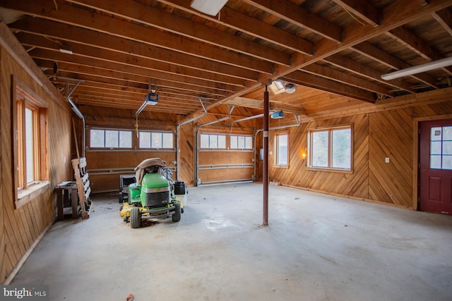 garage featuring a garage door opener and wooden walls