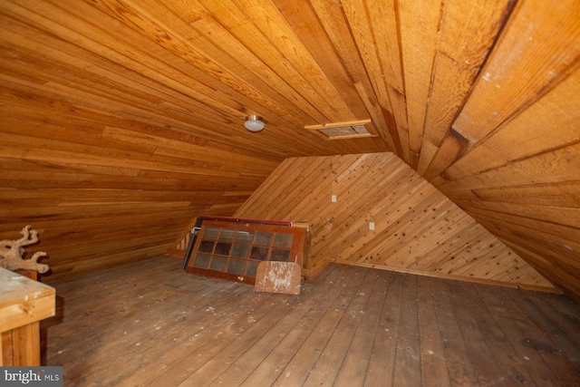 additional living space with wooden walls, wooden ceiling, vaulted ceiling, and hardwood / wood-style flooring