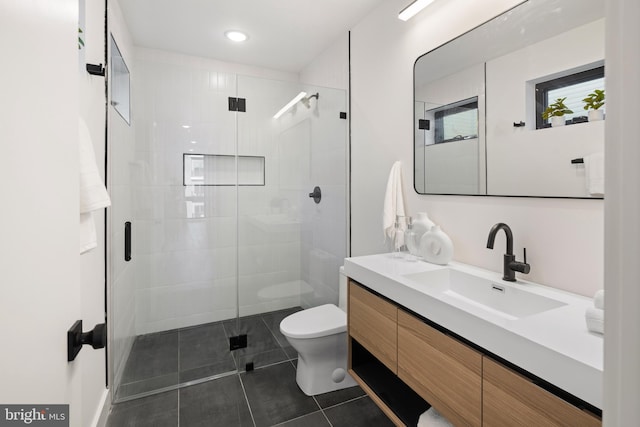 bathroom with tile patterned flooring, vanity, toilet, and a shower with door