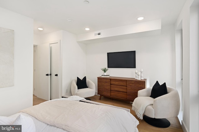 bedroom with light hardwood / wood-style floors and a closet