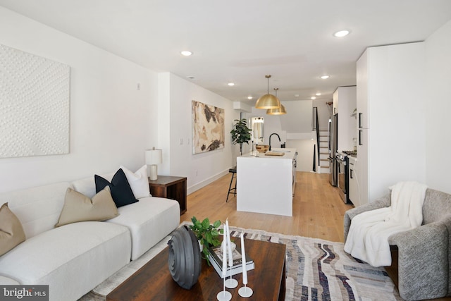 living room featuring light hardwood / wood-style flooring and sink