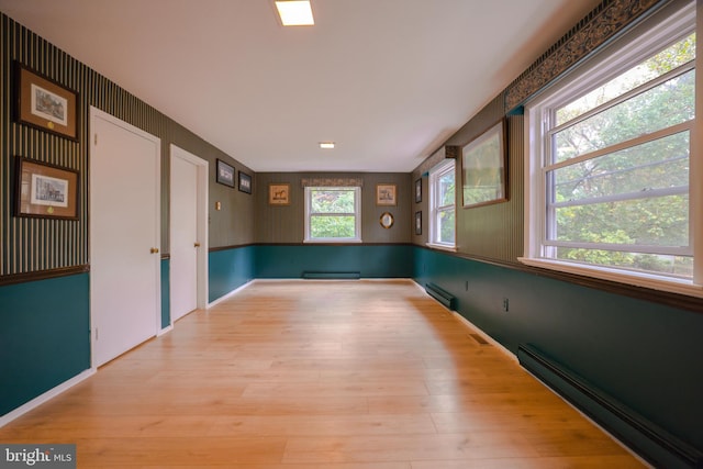 spare room featuring a baseboard radiator and a wealth of natural light