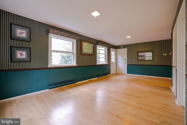 spare room featuring light hardwood / wood-style flooring and a baseboard heating unit