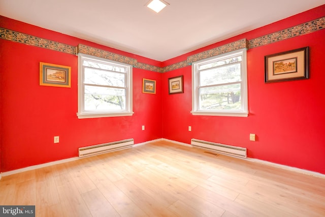 empty room with baseboard heating and wood-type flooring