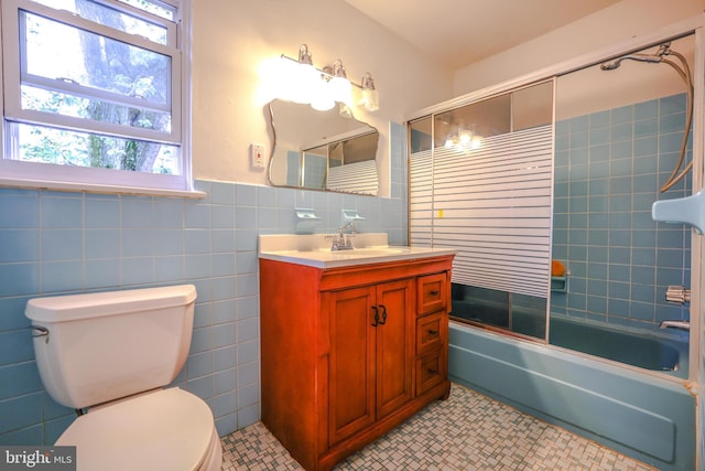 full bathroom with tile patterned floors, vanity, toilet, and bath / shower combo with glass door