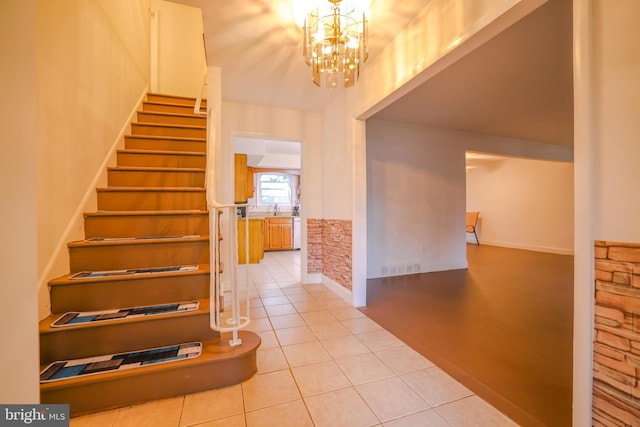 tiled entryway featuring sink and a notable chandelier