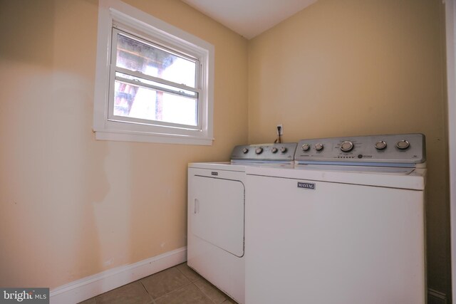 clothes washing area with light tile patterned floors and washer and dryer