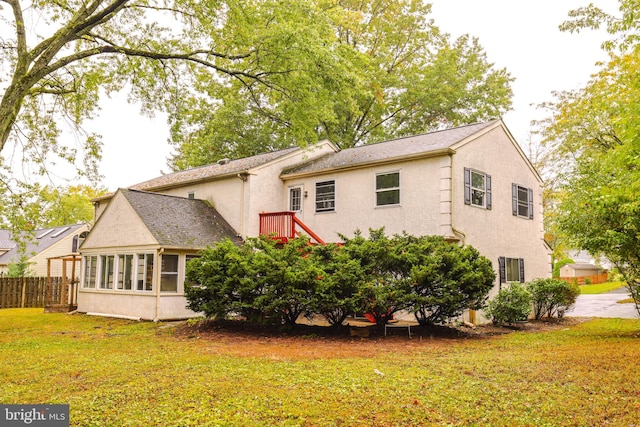 rear view of house featuring a lawn