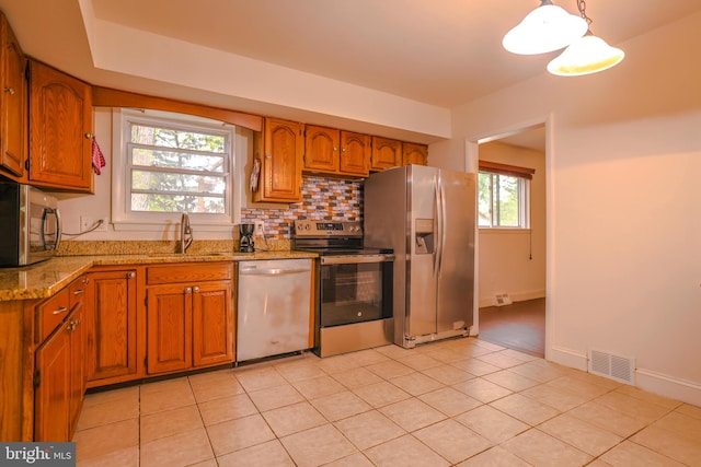 kitchen with light stone counters, sink, light tile patterned flooring, and appliances with stainless steel finishes