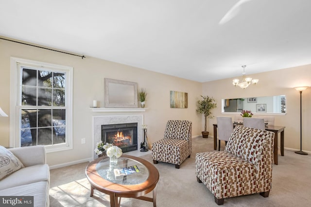 living room with light colored carpet, a premium fireplace, and a chandelier