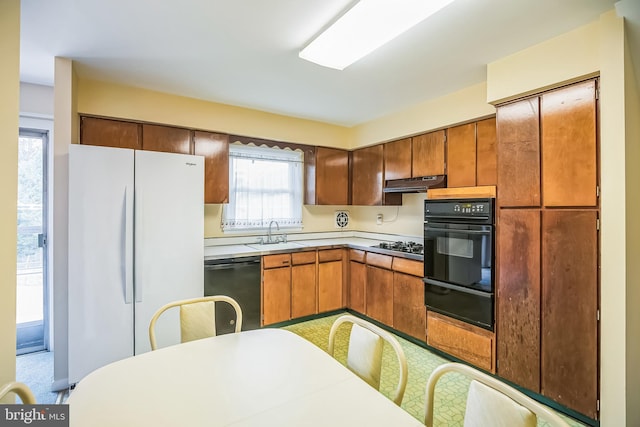 kitchen featuring black appliances, light colored carpet, and sink