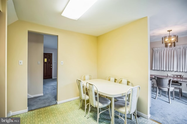 dining area featuring light carpet and an inviting chandelier