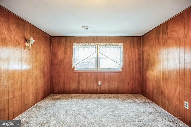 empty room with carpet flooring and wood walls