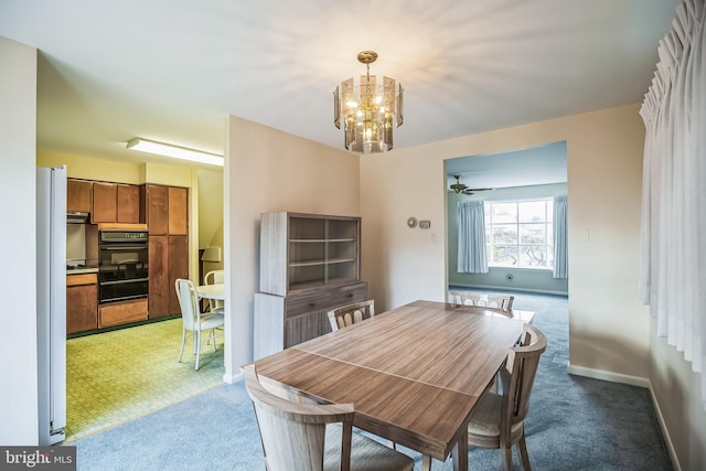 dining area featuring carpet and ceiling fan with notable chandelier