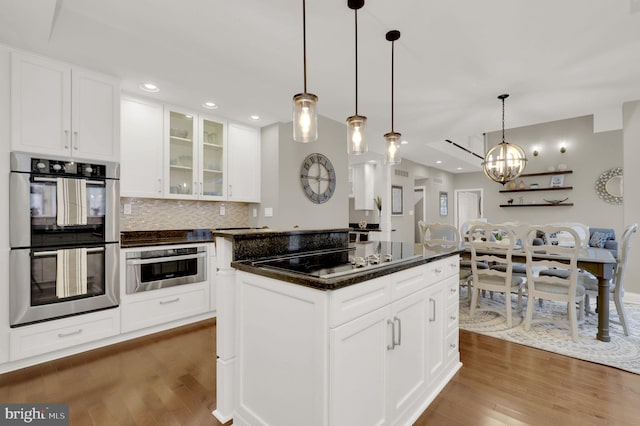 kitchen with a center island, stainless steel double oven, dark hardwood / wood-style floors, pendant lighting, and white cabinets