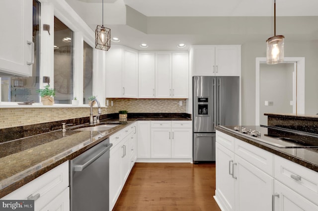 kitchen featuring sink, hanging light fixtures, stainless steel appliances, dark hardwood / wood-style floors, and white cabinets