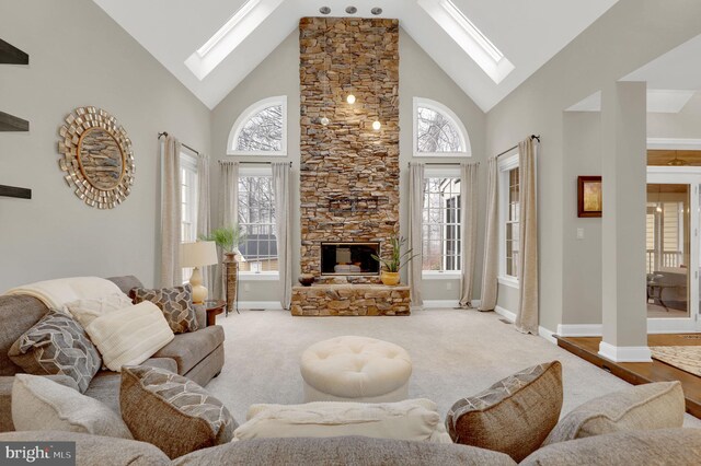 carpeted living room featuring a stone fireplace and high vaulted ceiling