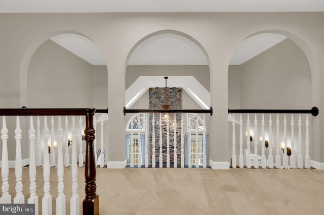 hall with carpet floors and high vaulted ceiling