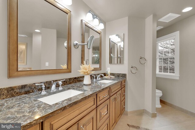 bathroom with tile patterned flooring, vanity, and toilet