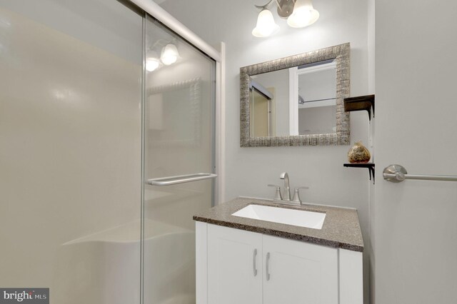 bathroom featuring vanity and a shower with shower door