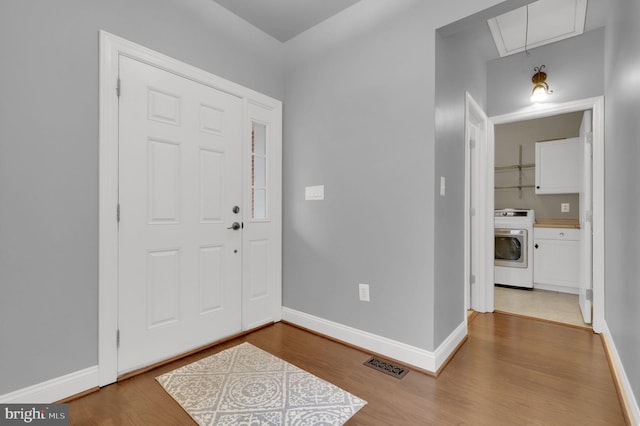 entrance foyer with hardwood / wood-style floors and washer / dryer