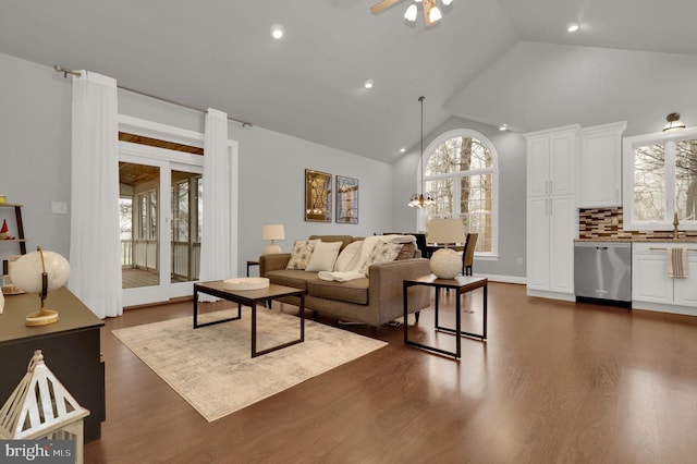 living room with high vaulted ceiling, ceiling fan, dark wood-type flooring, and sink