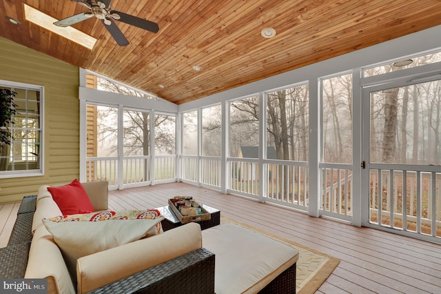 sunroom / solarium featuring ceiling fan, vaulted ceiling with skylight, and wood ceiling