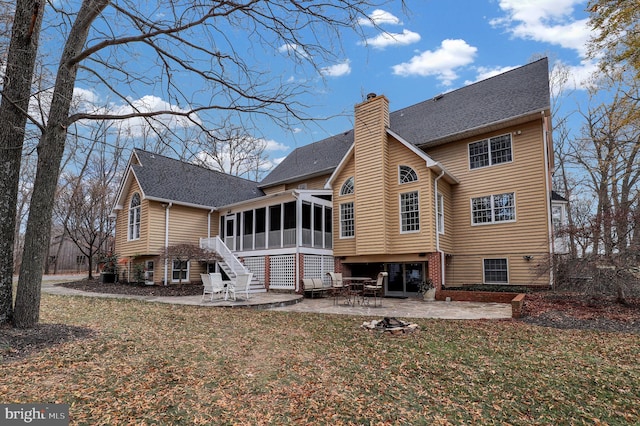 rear view of property with a patio, a lawn, and a sunroom