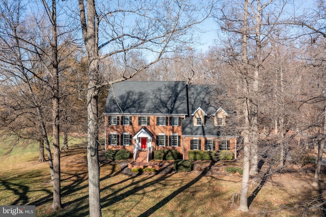 colonial-style house with a front lawn