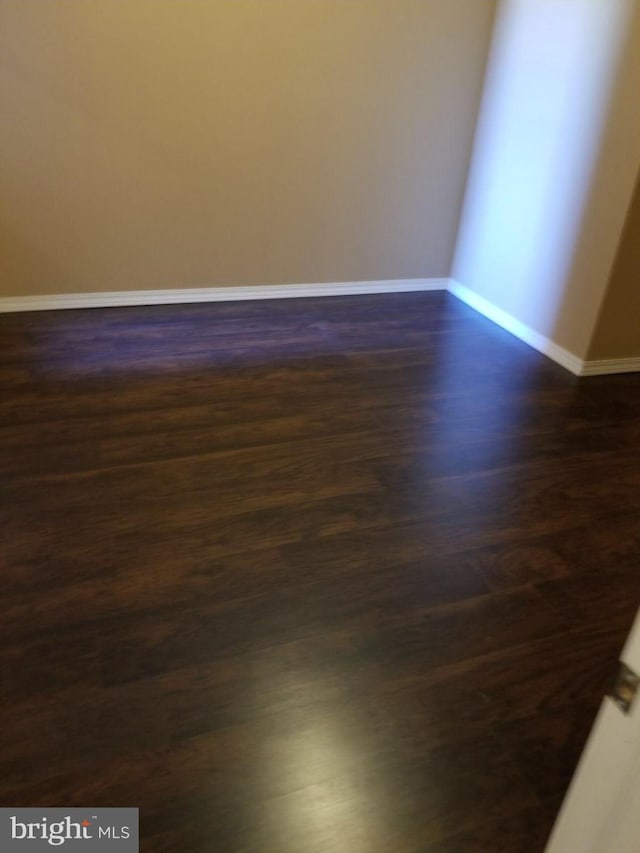 empty room with dark wood-type flooring