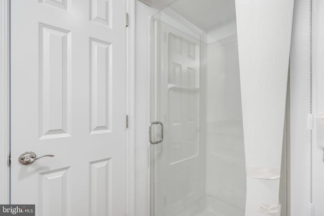 interior details with a shower with door