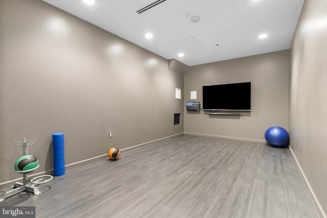 exercise room with light hardwood / wood-style floors