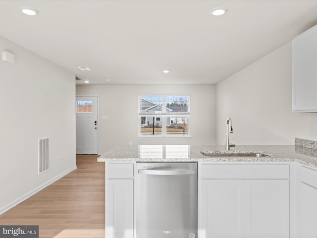 kitchen with white cabinetry, sink, light stone counters, stainless steel dishwasher, and light hardwood / wood-style floors