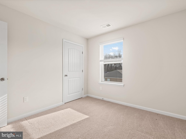 unfurnished room featuring light carpet