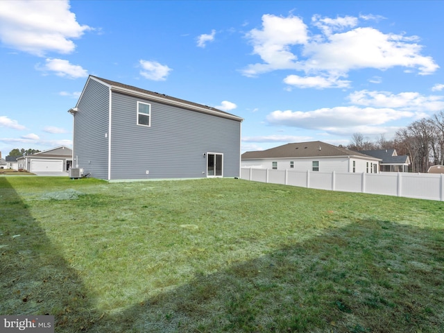 back of property featuring a yard and central AC