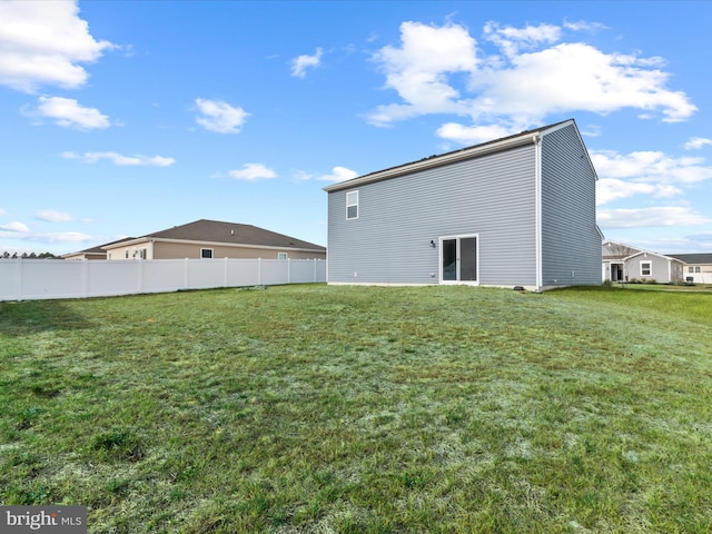 back of house with a lawn