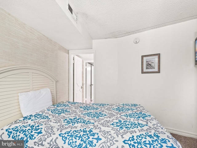 bedroom featuring carpet floors and a textured ceiling