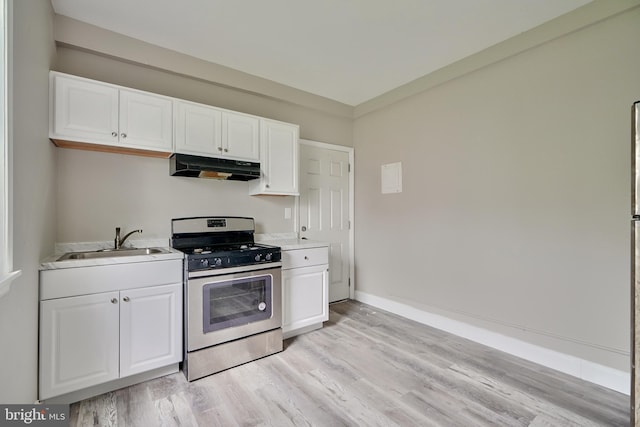 kitchen with white cabinets, light wood-type flooring, sink, and stainless steel gas range