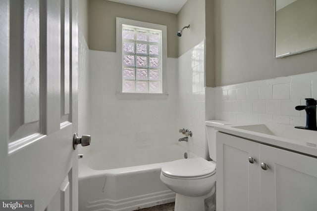 full bathroom with vanity, toilet, tiled shower / bath, and tile walls