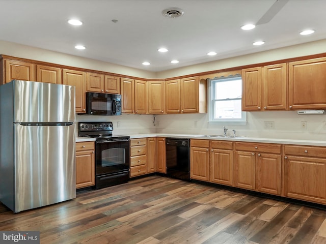 kitchen featuring sink, dark hardwood / wood-style floors, and black appliances