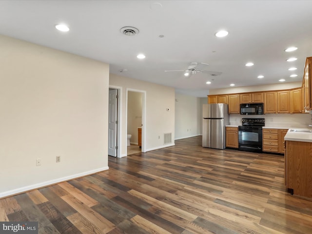 kitchen featuring ceiling fan, dark hardwood / wood-style flooring, black appliances, and sink