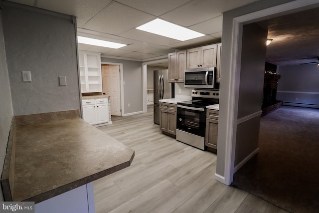 kitchen with ceiling fan, stainless steel appliances, a baseboard heating unit, a paneled ceiling, and light wood-type flooring