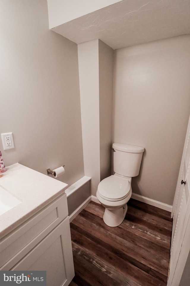 bathroom featuring vanity, toilet, and wood-type flooring