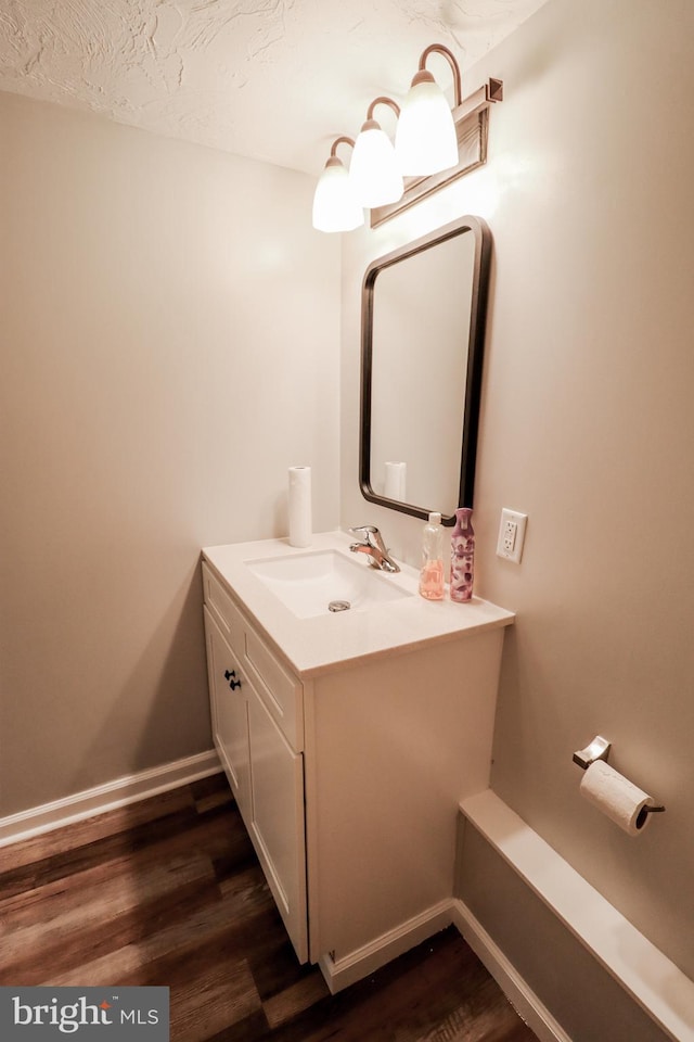 bathroom with hardwood / wood-style flooring, vanity, and a textured ceiling