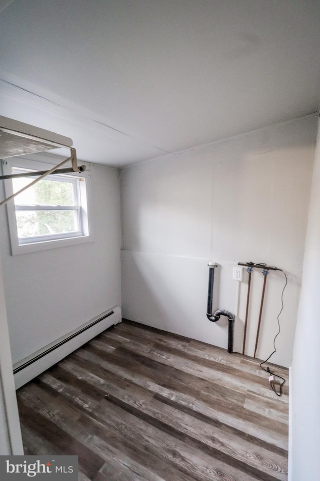 unfurnished room featuring dark hardwood / wood-style flooring and baseboard heating